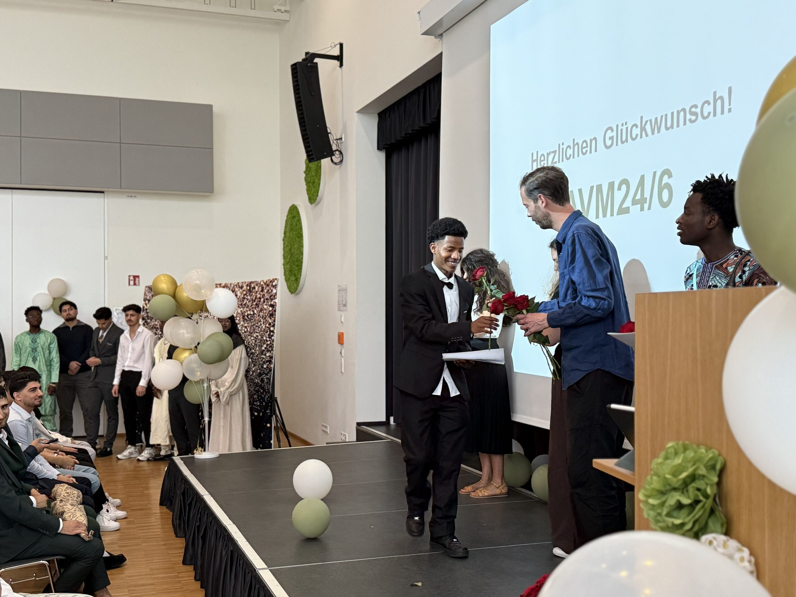 Schüler bekommt rote Rose auf Bühne überricht